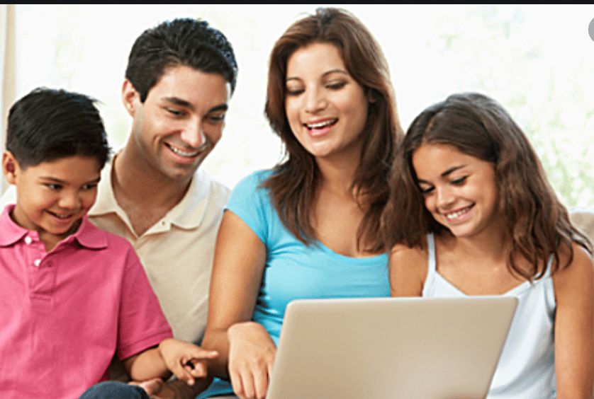 Family smiling at laptop screen